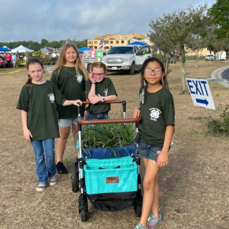 Four youth with a cart full of plants