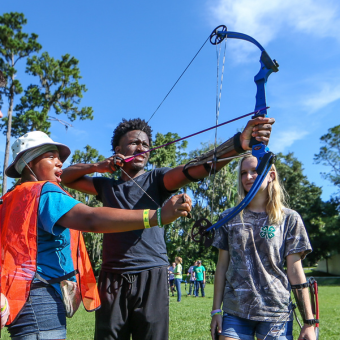 Photo of youth showcasing their archery skills during a workshop at 4-H University