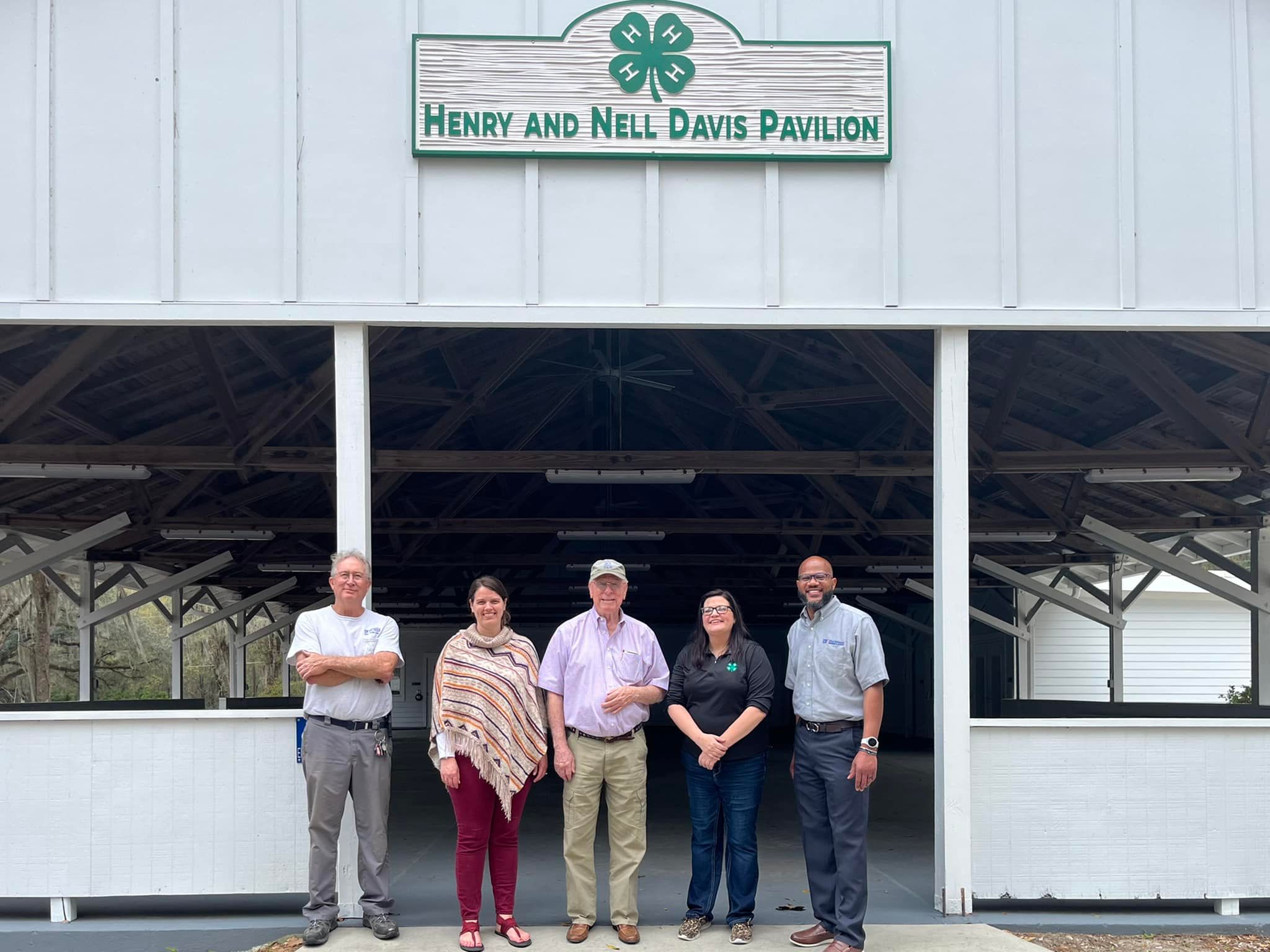 Five individuals standing in front of the Henry and Nell Davis Pavilion.