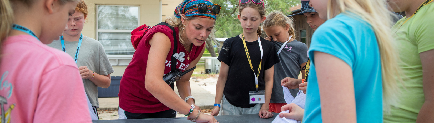 Photo of camp counselor showing campers how to use tie-dye