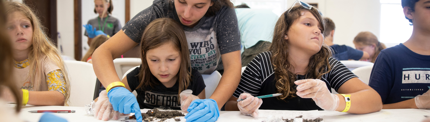 Photo of youth looking at specimen at Camp Cloverleaf