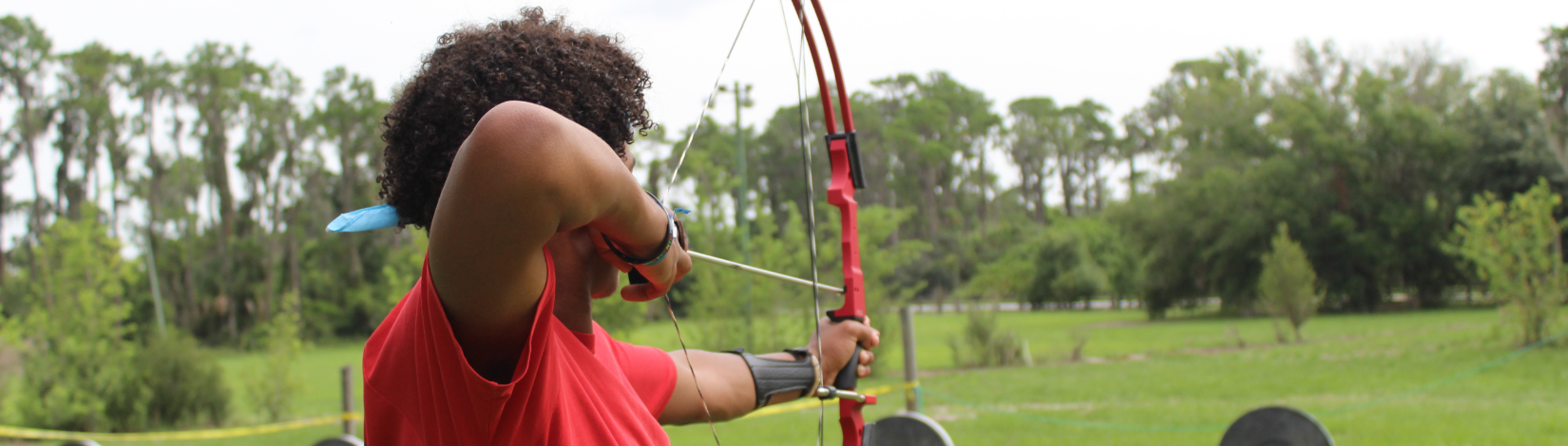 Banner image of youth with a bow and arrow